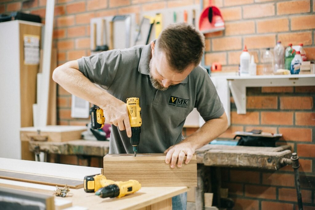 man using drill in slab of wood